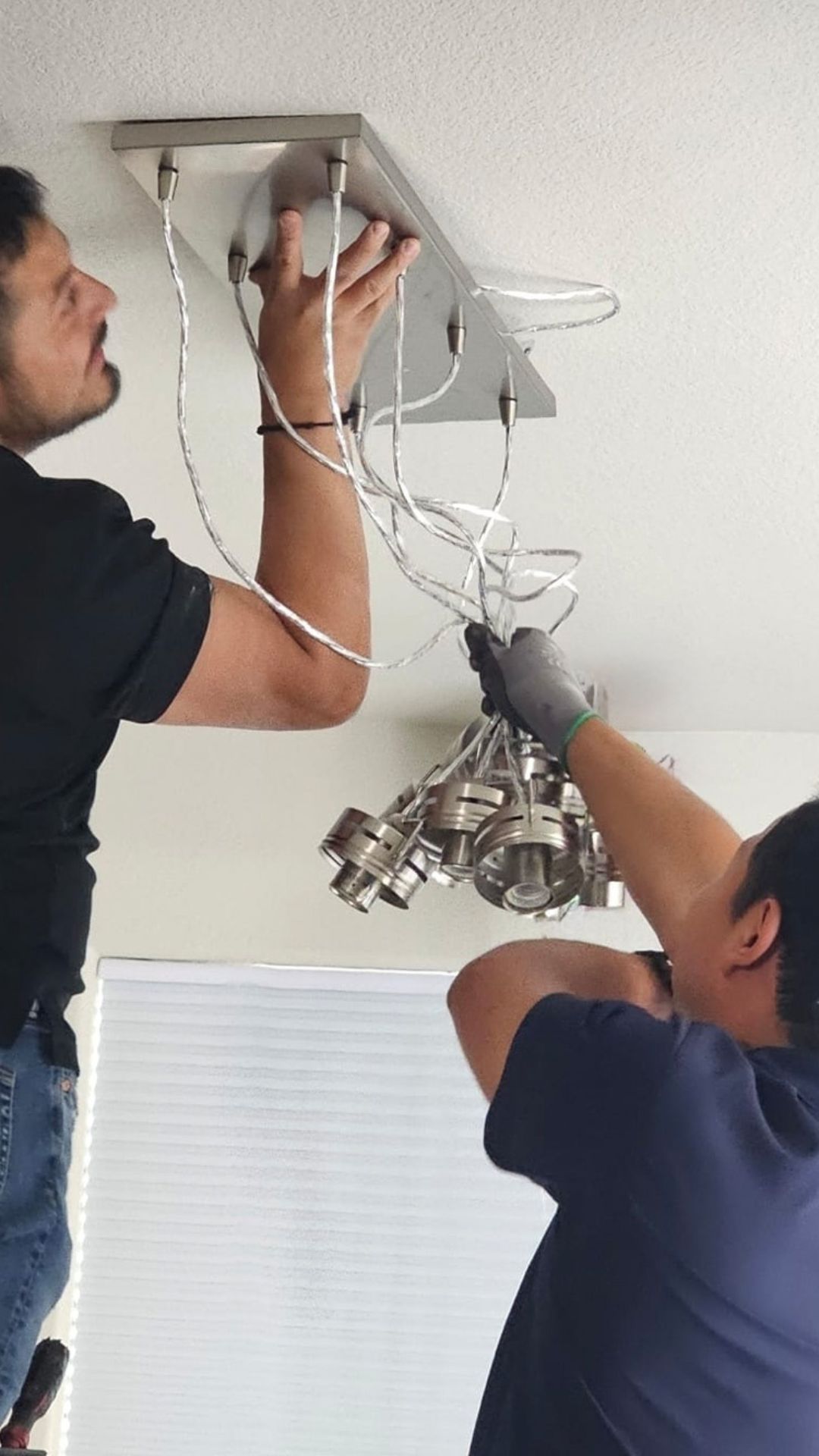 Boyes Electric electrician installing light fixture during residential service in home